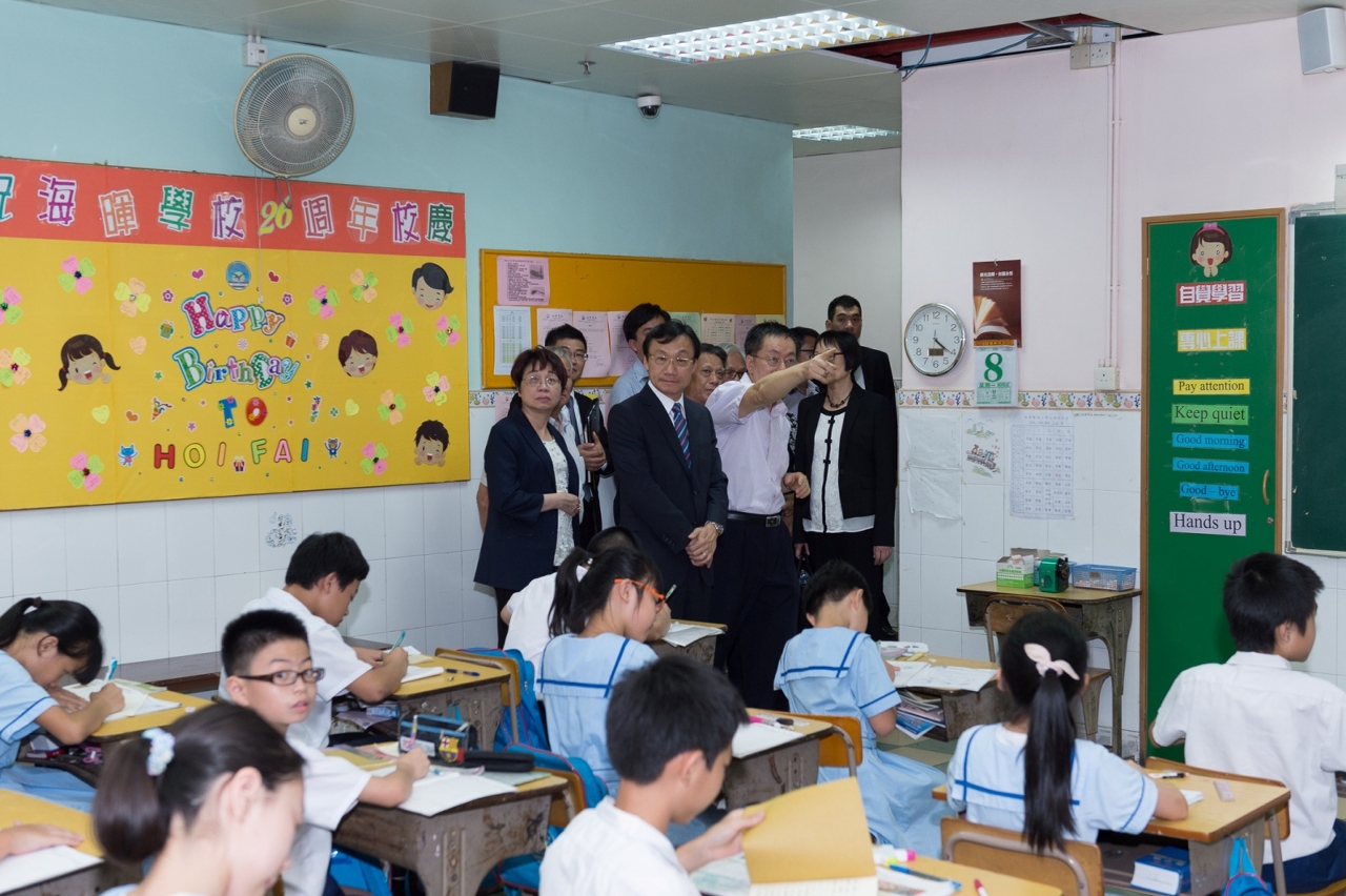 譚俊榮在海暉學校校長戴燦林陪同下考察課室情況