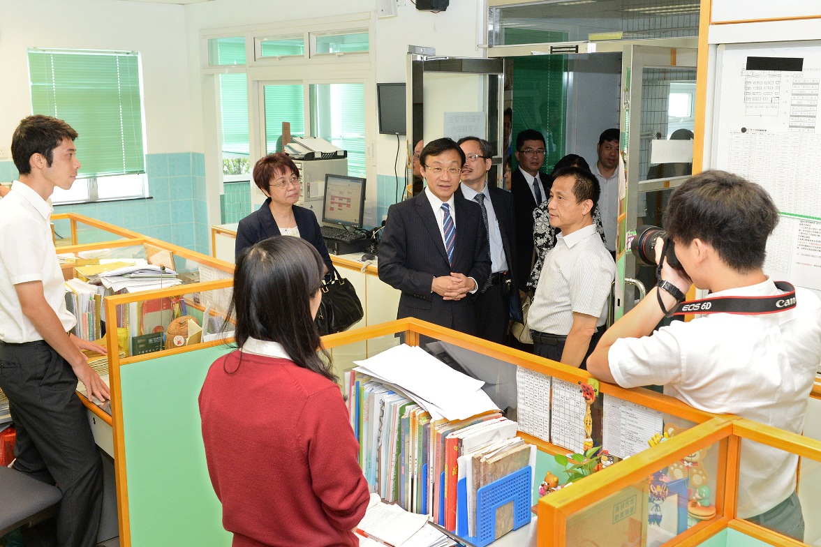 譚俊榮在菜農子弟學校校長陪同下走訪教師辦公室