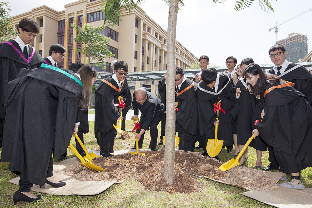 The Class of 2015 graduates plant a flame tree on the campus