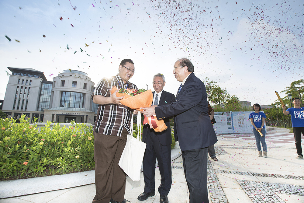 UM representatives present flowers and a souvenir to the 10,000th visitor to UM