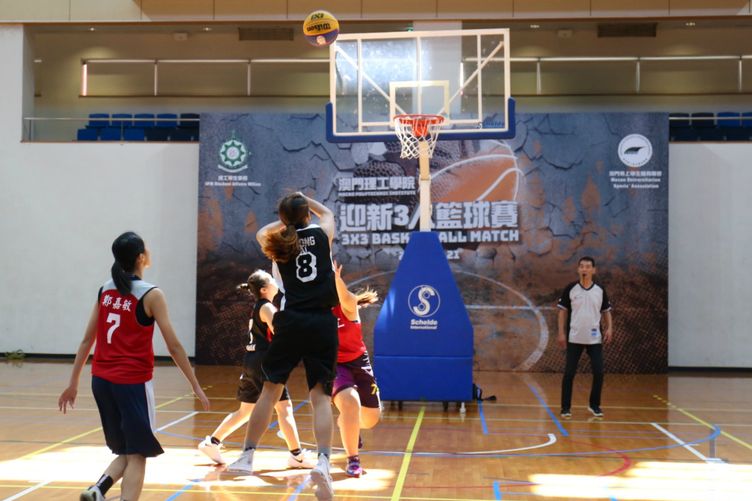 A team competing in the female division scoring with a jump shot