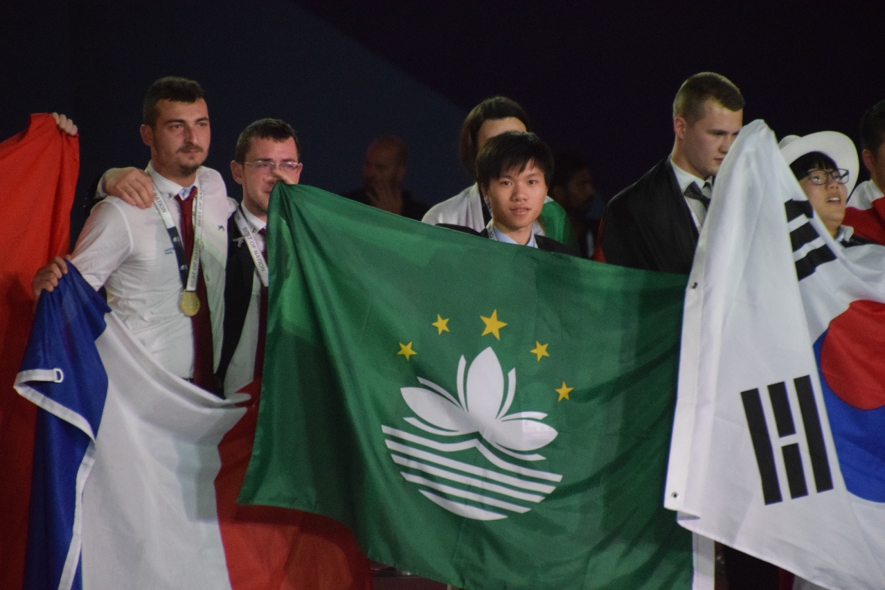 O concorrente de Macau que obteve a medalha de ouro, recebe votos de felicidades no palco