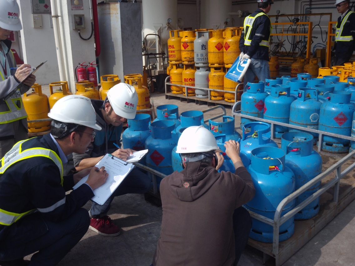 Os trabalhadores que procedem testes registam as amostras de gás de petróleo recolhidas