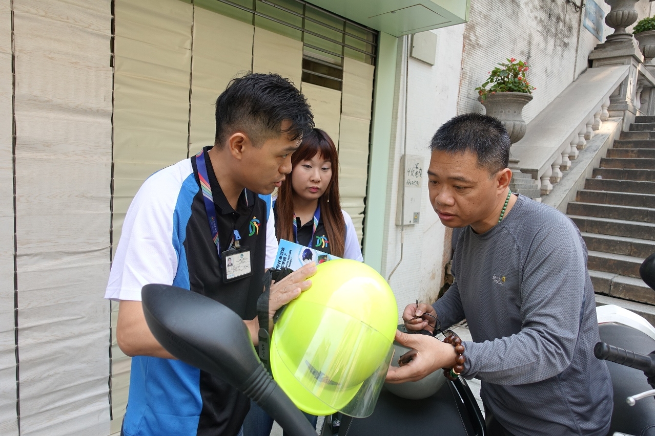 交通事務局人員為市民檢視頭盔