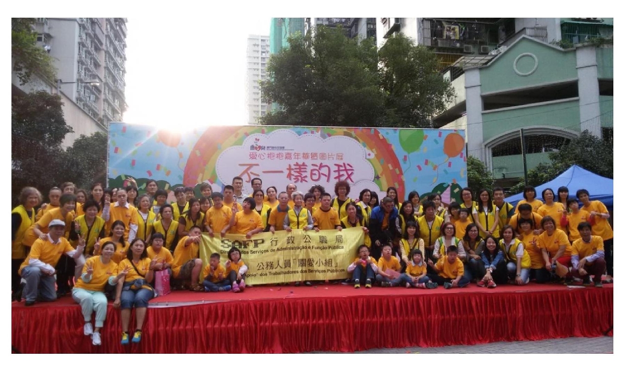 Fotografia de grupo dos trabalhadores voluntários da função pública com as pessoas com síndrome de Down na “Festa de Abraços com Amor e Exposição de Fotografias”