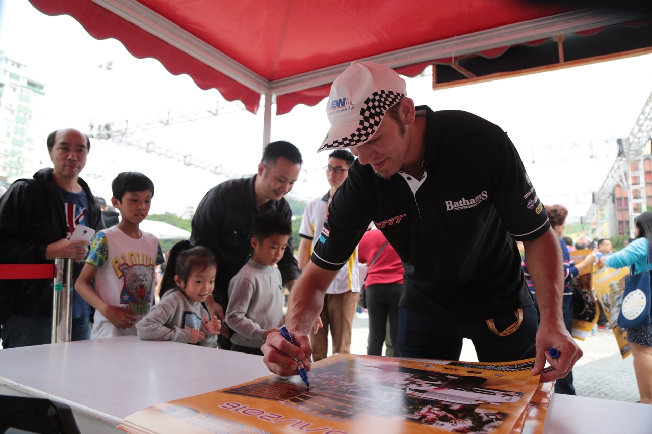 O campeão predominante do Grande Prémio de Motos de Macau Peter Hickman, a assinar os cartazes para os fãs encantados mais novos.