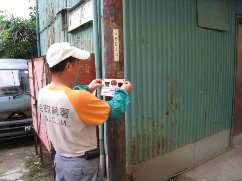 民署人員張貼告示提醒居民留意