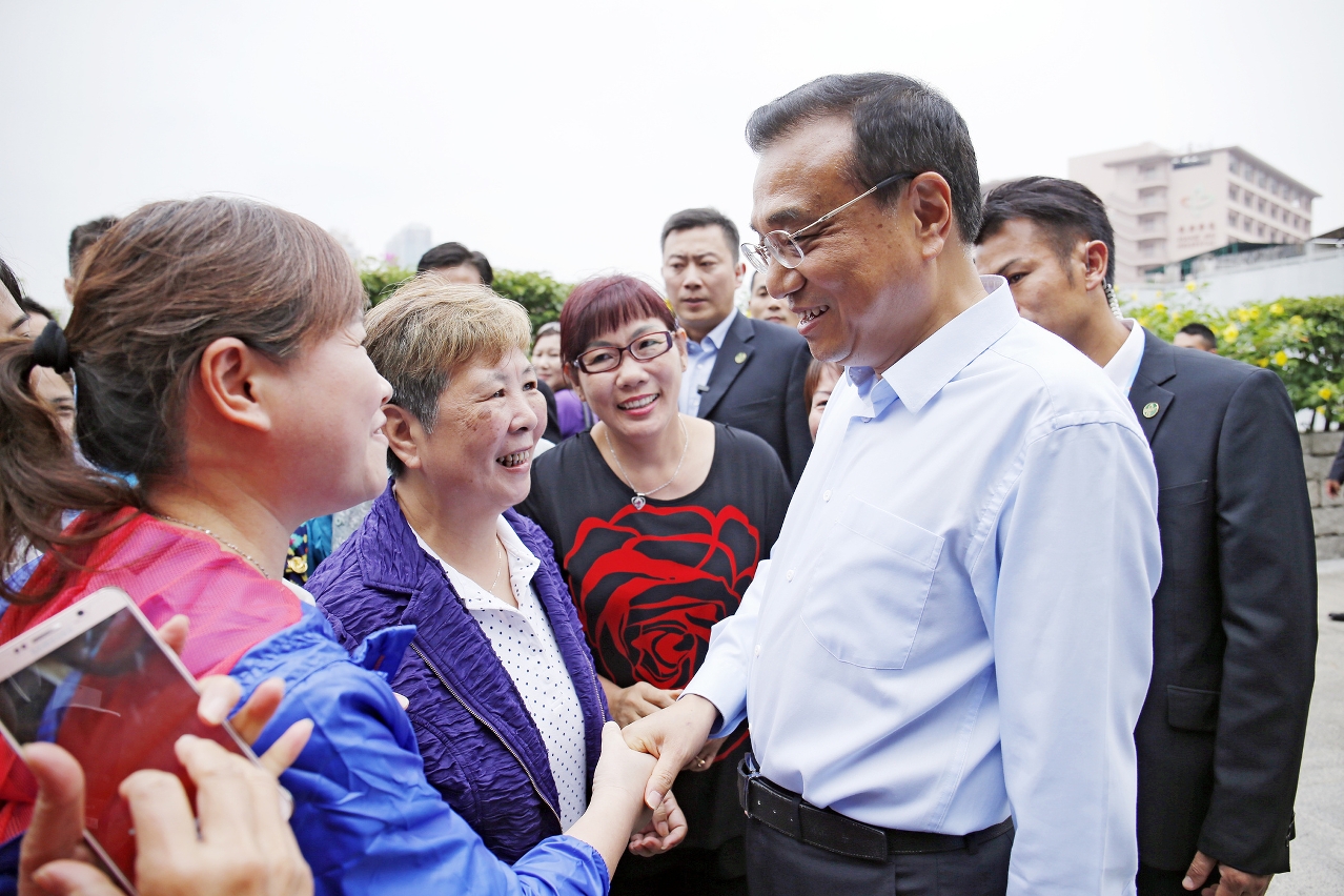Premier Li Keqiang greets members of the public during a community visit.
