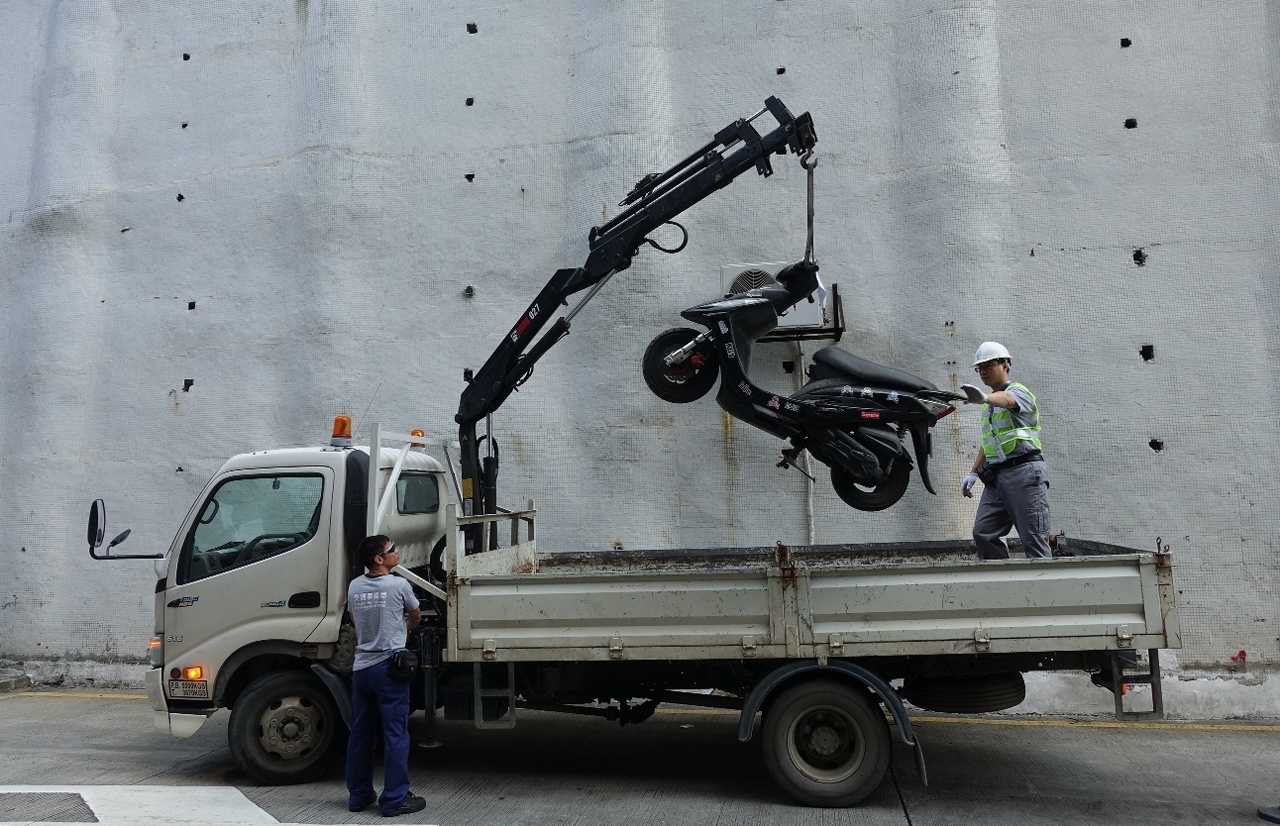 O pessoal da DSAT remove os veículos abusivamente estacionados no parque de estacionamento.
