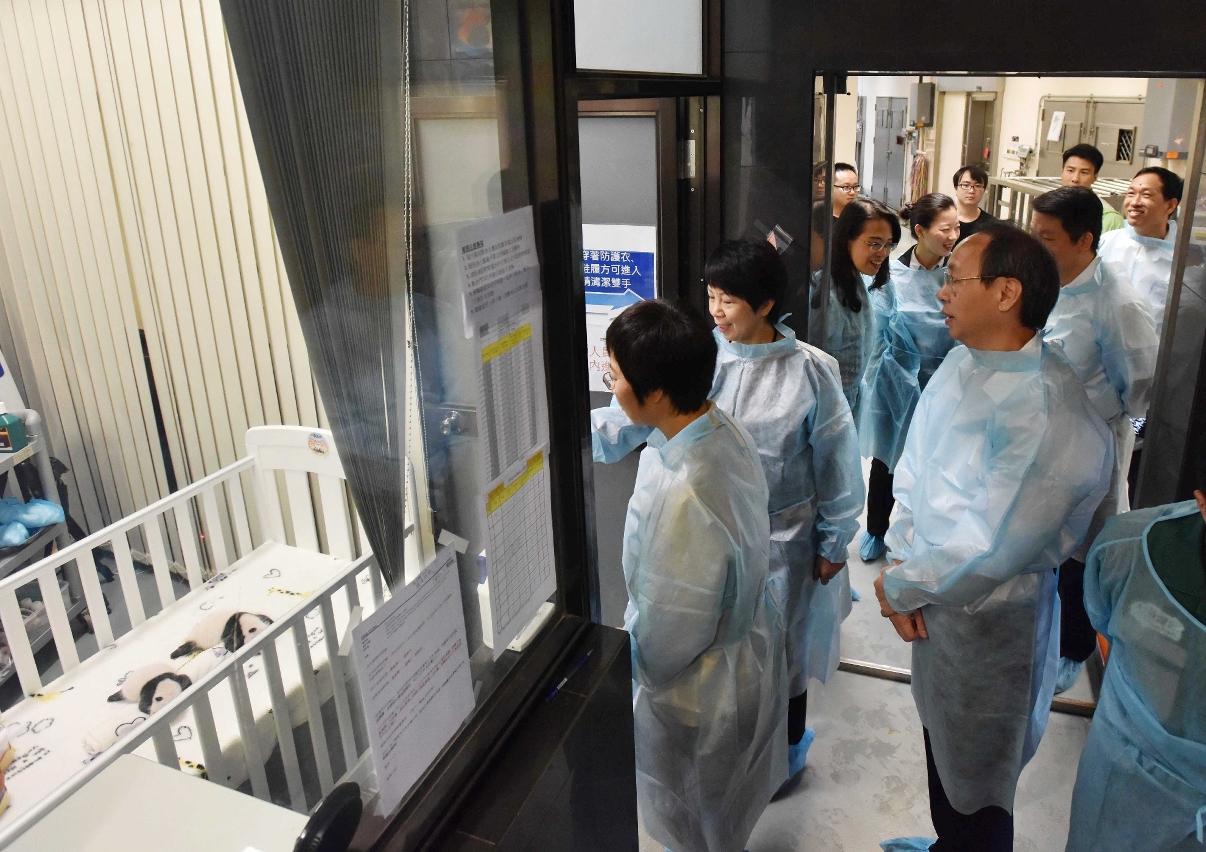 The Secretary for Administration and Justice, Ms Chan Hoi Fan (front, centre), visits the month-old twin male giant panda cubs.