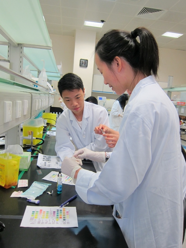 參與夏令營的中學生在衛校老師指導下鑒定自己血型，樂在其中