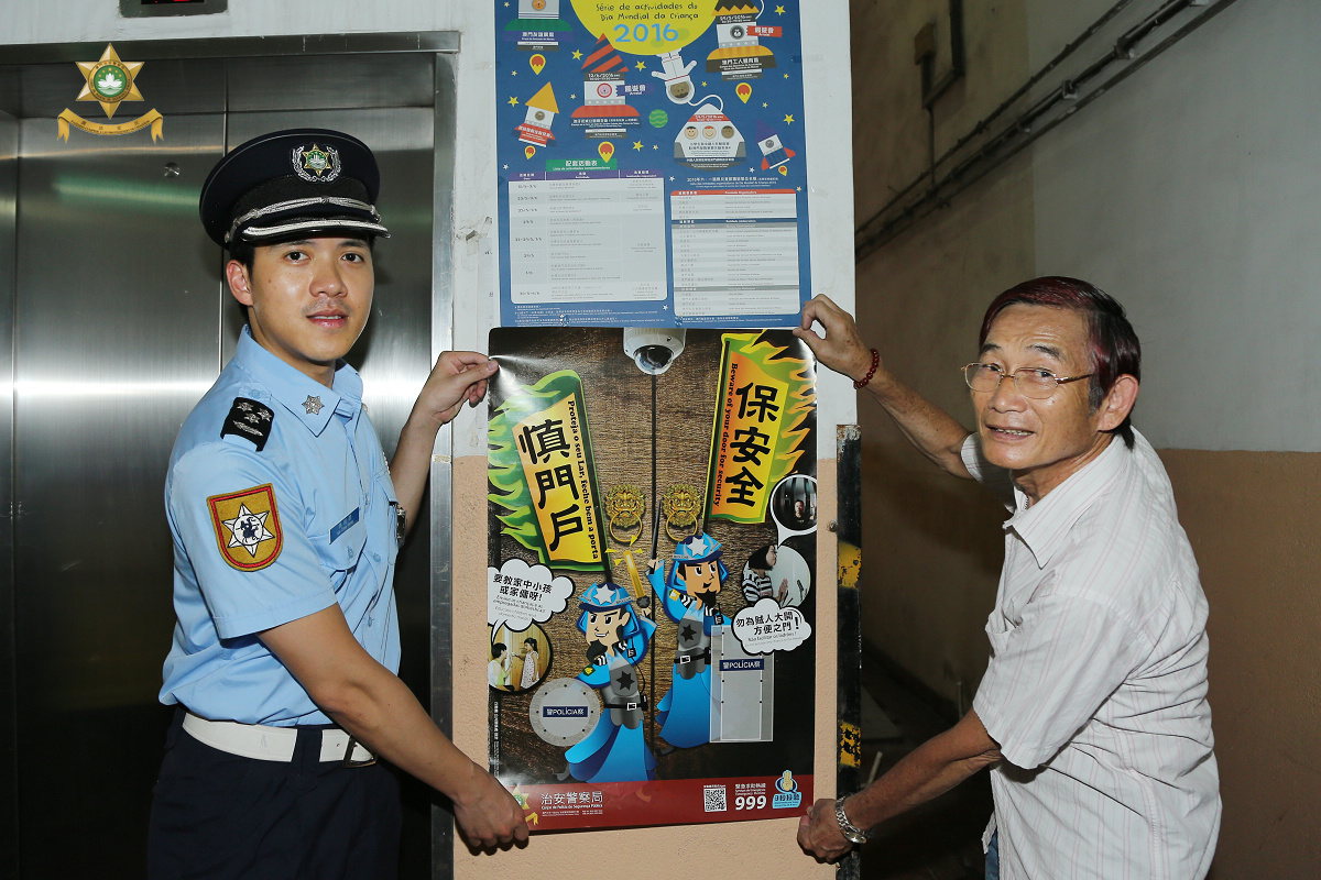治安警馬超雄警司與台山坊眾互助會黃長順副理事長向區內大廈派發宣傳海報
