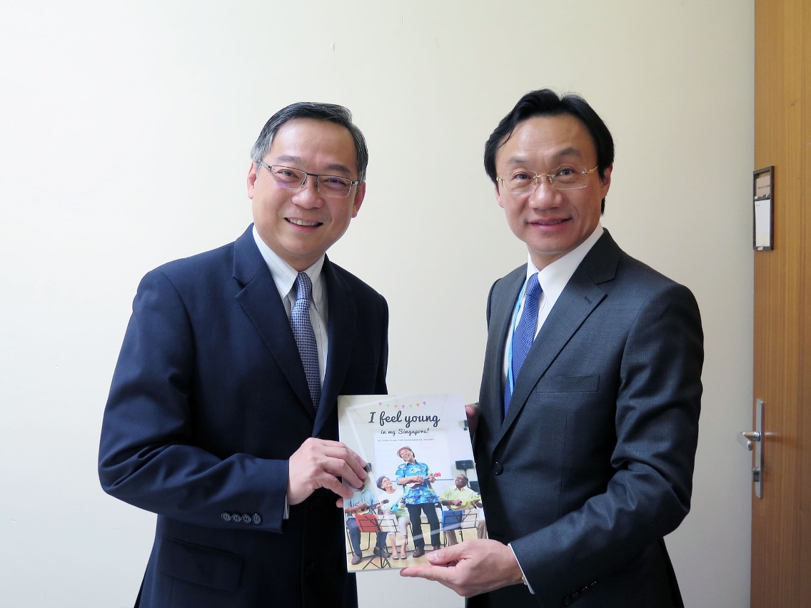 Mr Tam Chon Weng exchanges gifts with Singapore’s Minister for Health, Mr Gan Kim Yong (left), after signing a memorandum of cooperation in Geneva, Switzerland