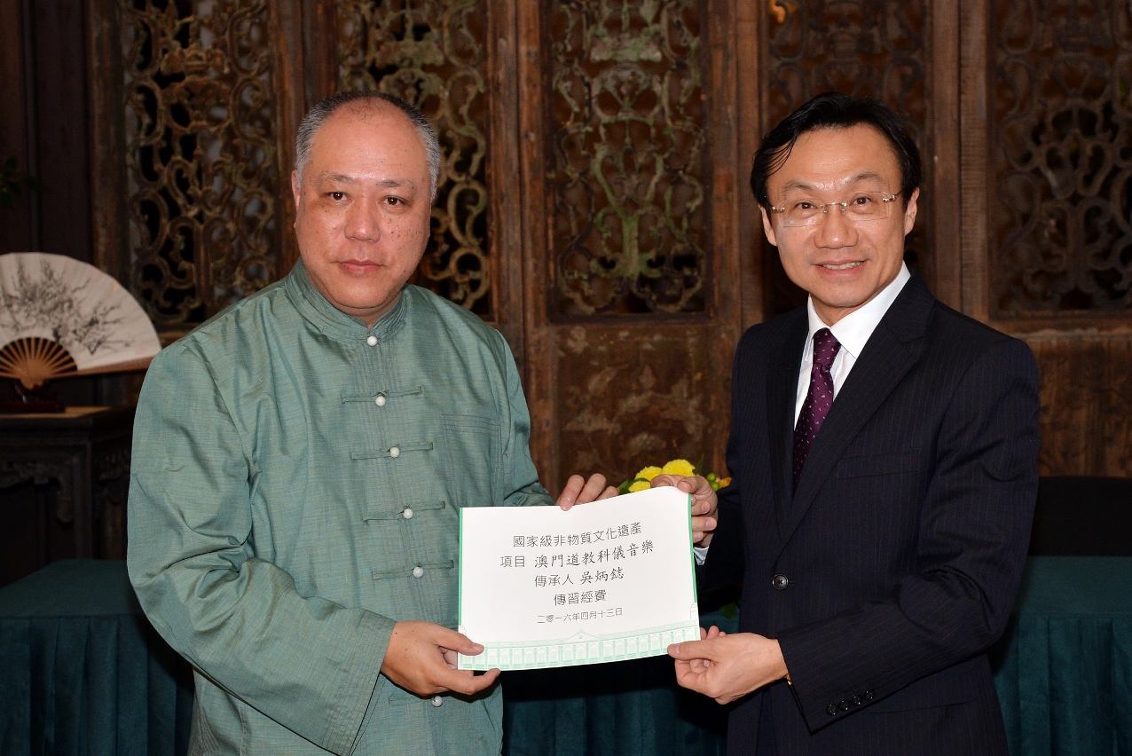 澳門特別行政區社會文化司司長譚俊榮(圖右)向澳門之國家級“非遺＂－澳門道教科儀音樂傳承人吳炳鋕(圖左)頒發傳習經費