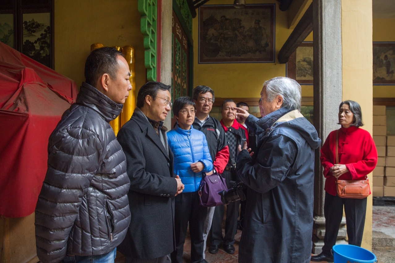 Secretary for Social Affairs and Culture, Mr Tam Chon Weng, is briefed by manager of A-Ma Temple following accidental fire.