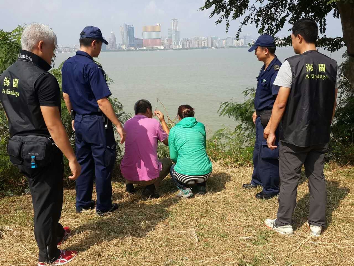 海關人員帶同兩名非法入境者在上岸現場作案件調查工作