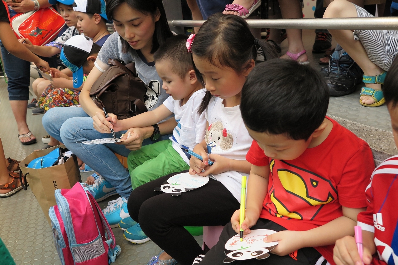 Children are writing birthday wishes for giant panda “Kai Kai”.
