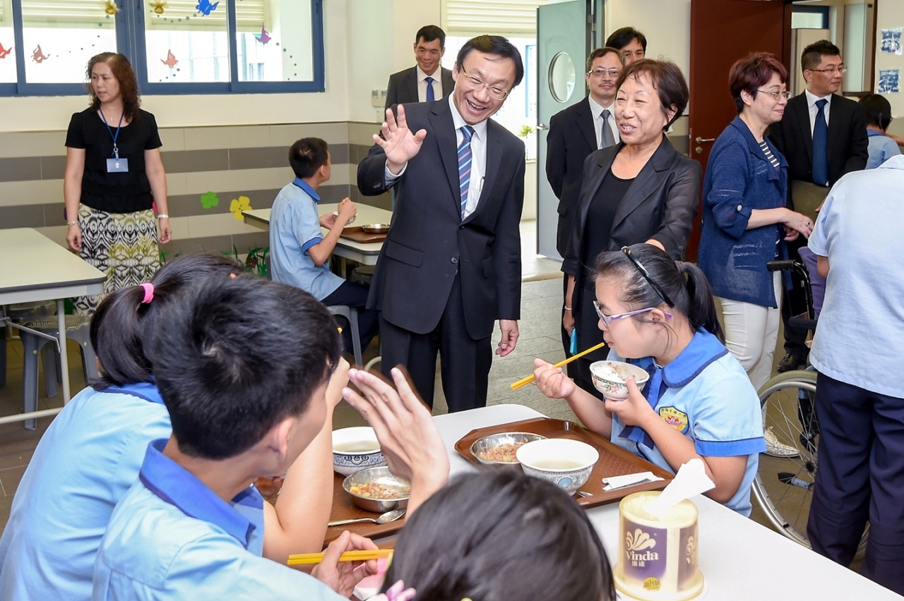 Secretary for Social Affairs and Culture, Mr Tam Chon Weng, tours the canteen of the school.