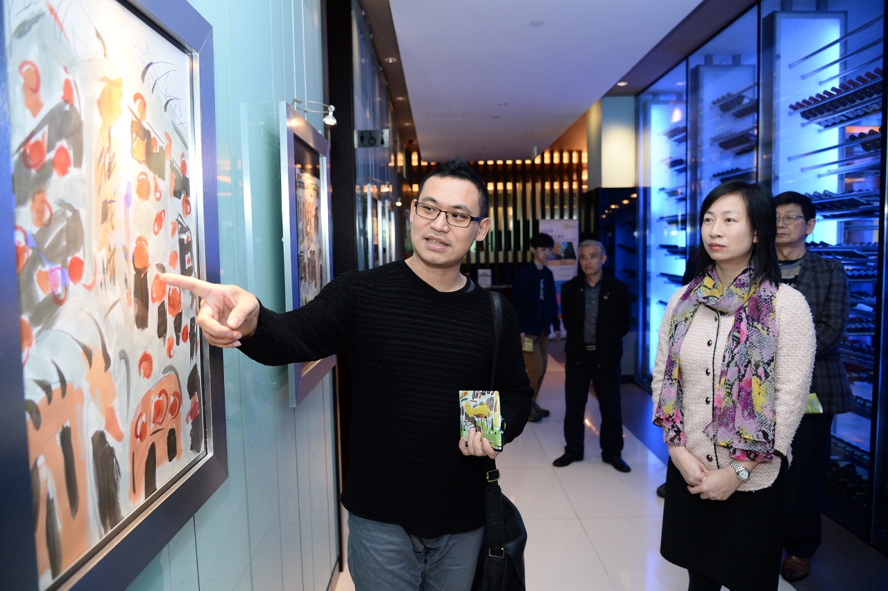 Mr. Cai elaborating his paintings for guests