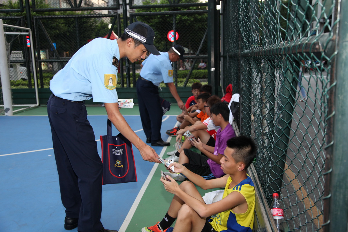 治安警向球場青少年派發宣傳小冊子