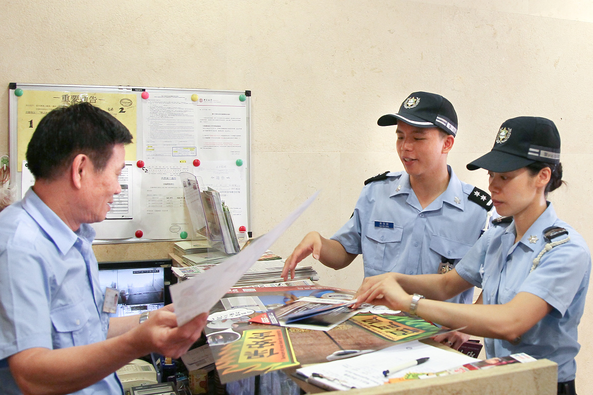 治安警向大廈管理員派發慎門戶、保安全宣傳海報