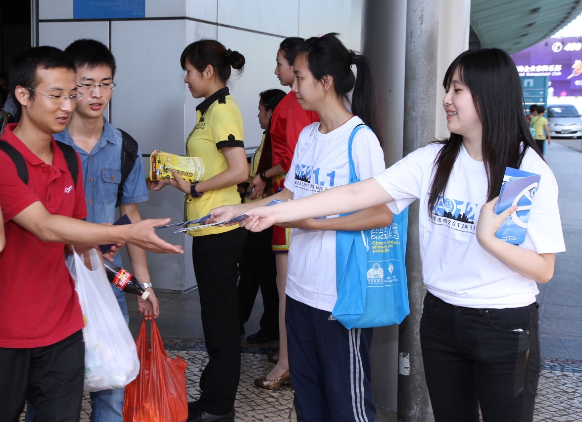 社團義工在口岸向抵澳旅客派發新控煙法宣傳單張