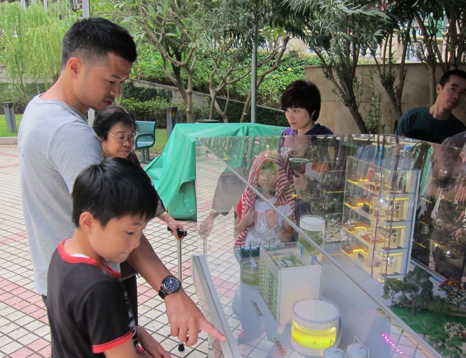 家長利用模型為孩子講解城市水循環過程