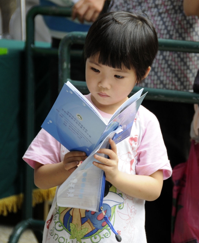小朋友專心閱讀小組贈送的節水手冊