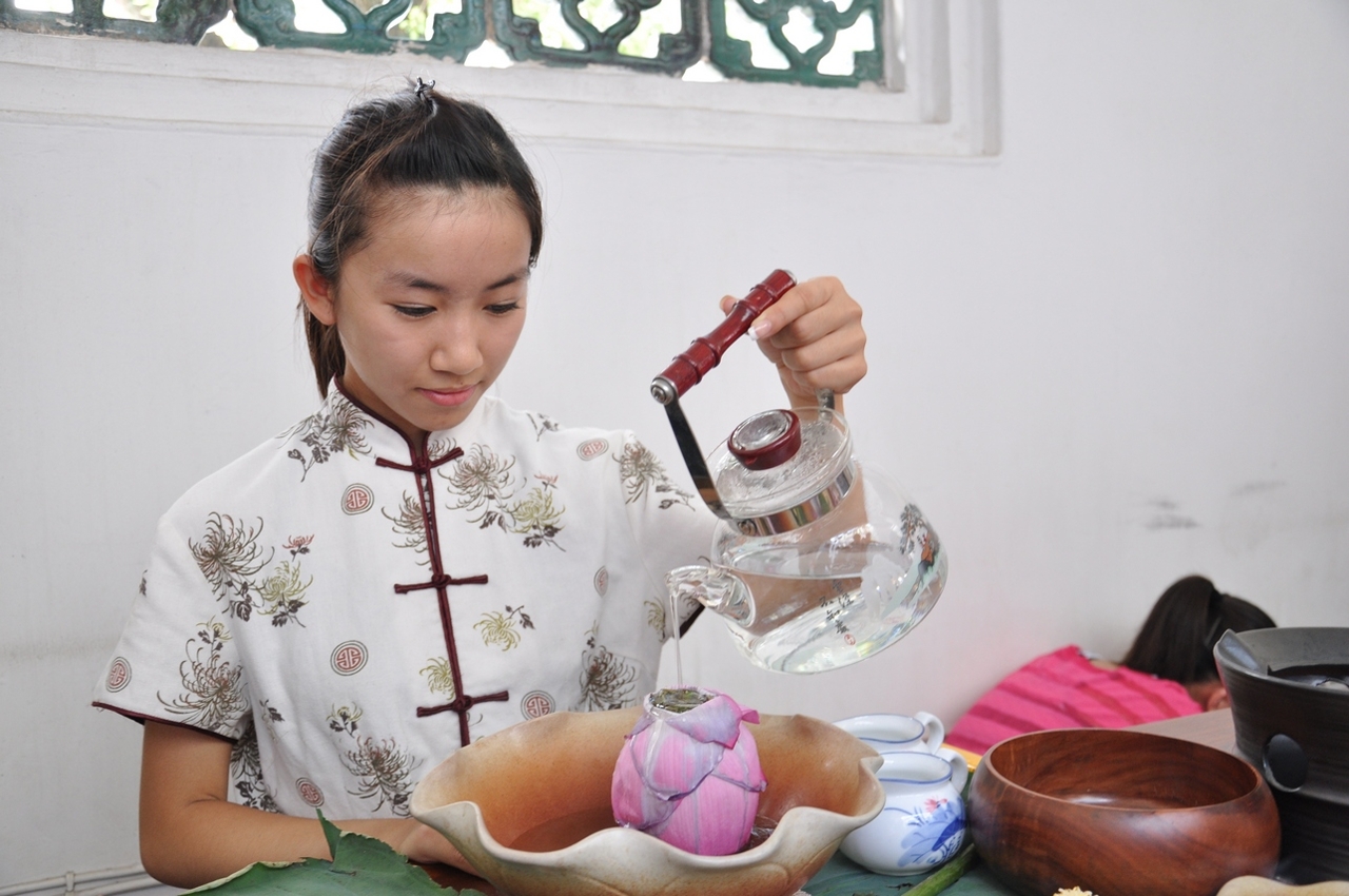 泡茶導師在鄭家大屋方形內院即席示範泡製荷花茶。