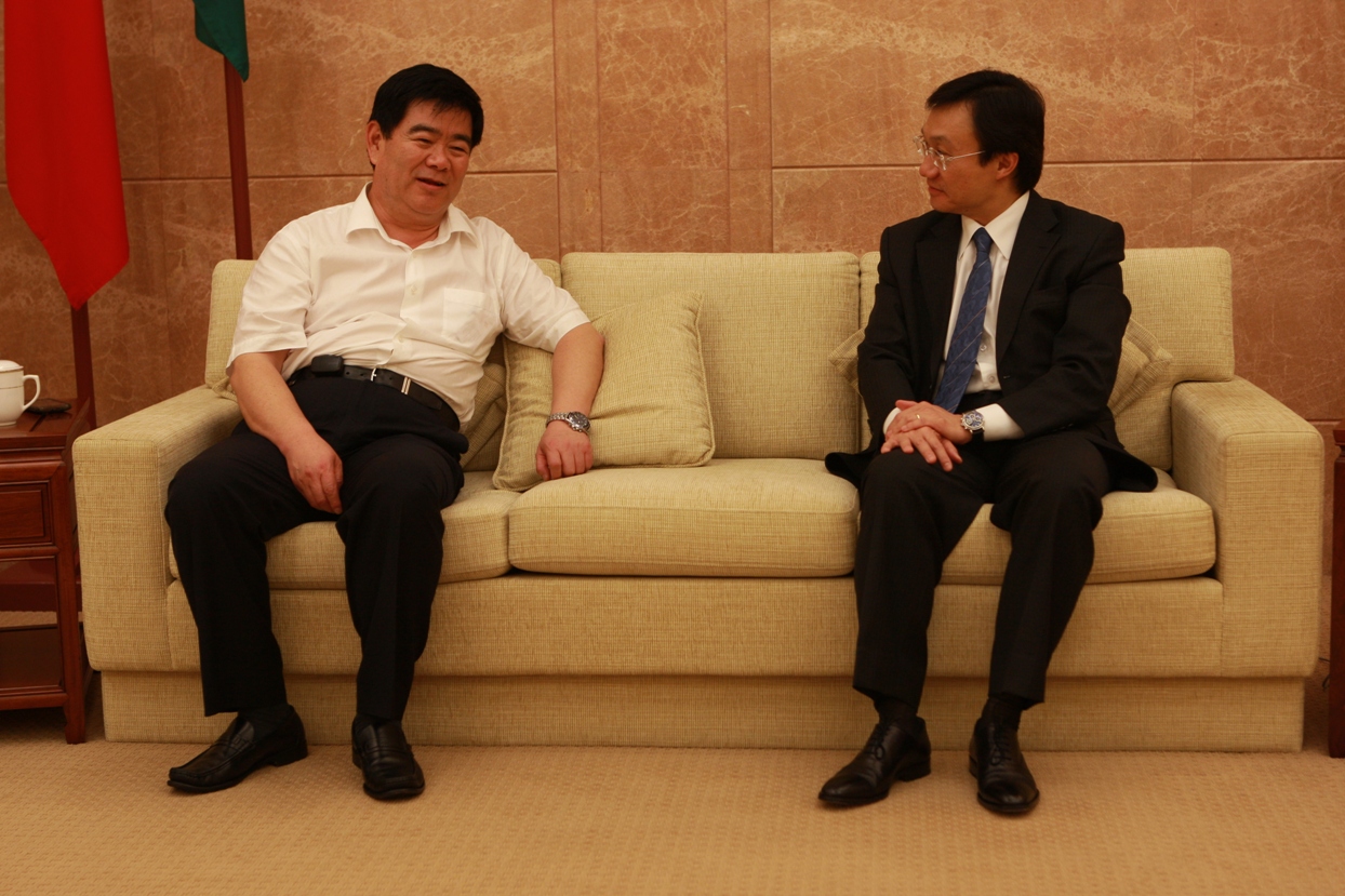 行政長官辦公室主任、政府發言人譚俊榮向人民日報海外版總編輯張德修介紹澳門發展