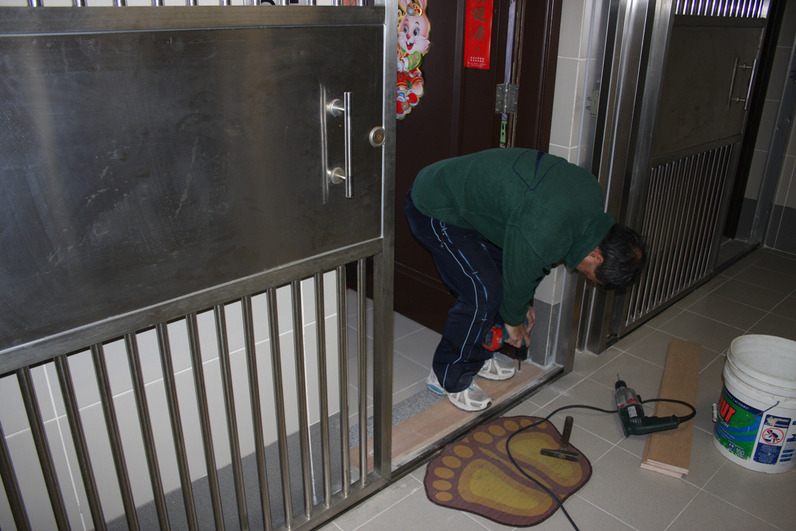 工作人員加緊為青松樓社屋單位進行平整門隙工程