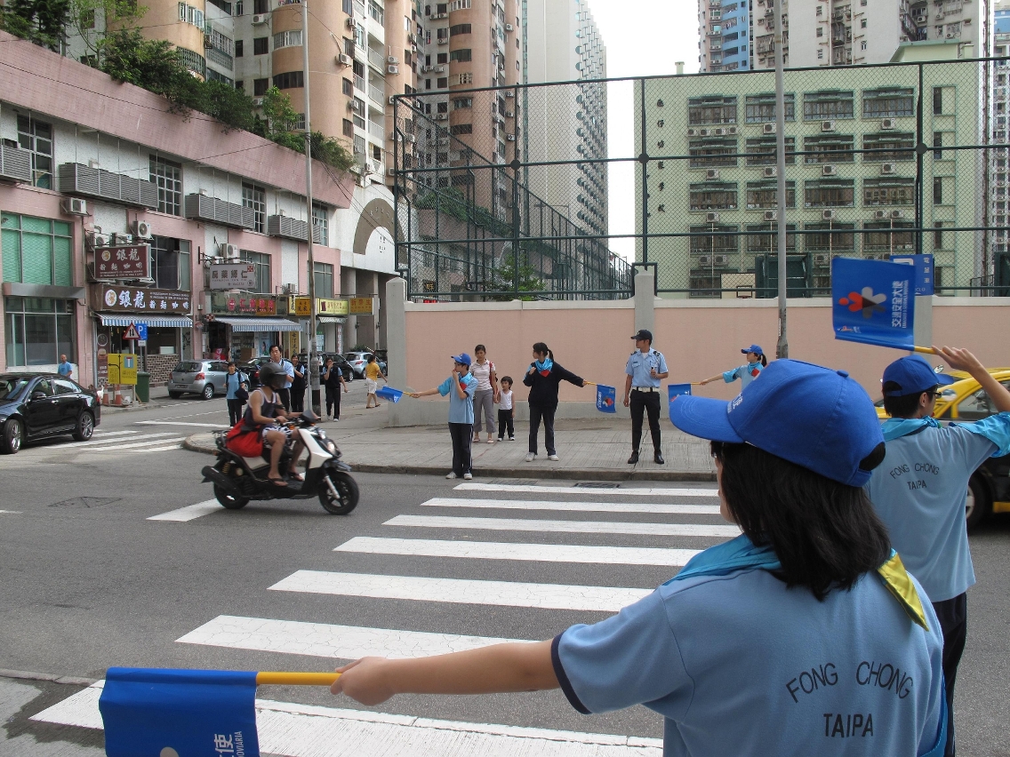 交通安全大使在警方指導下協助同學安全橫過馬路