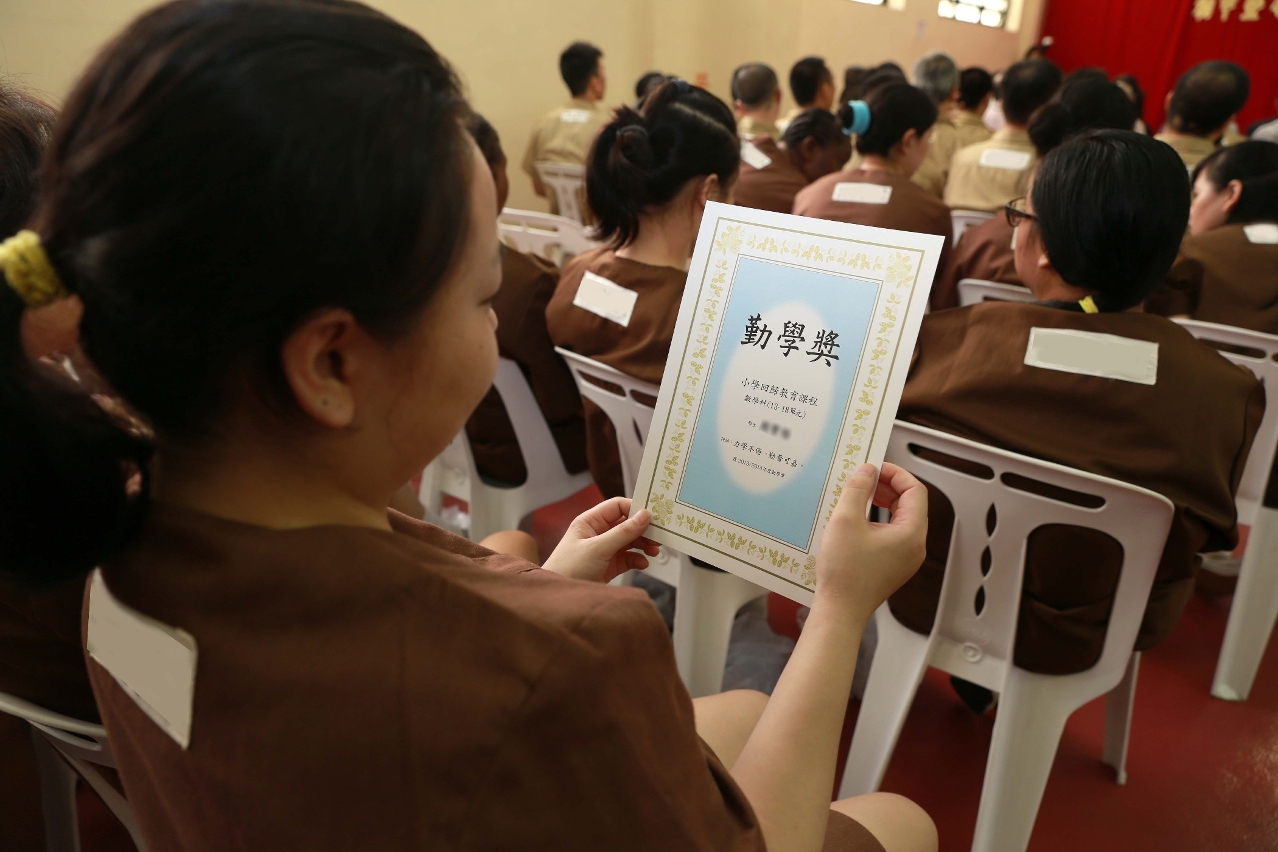 Reclusos alegres com certificado do curso nas mãos