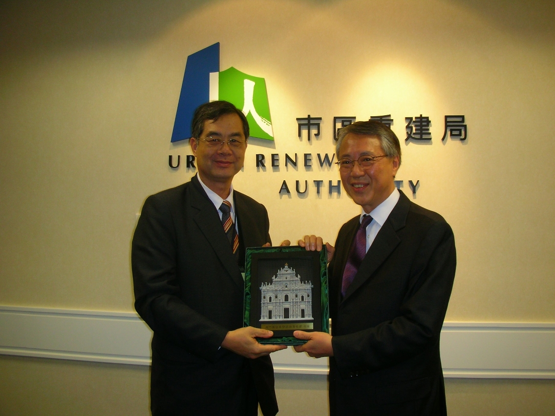 補償小組召集人梁竟成向觀塘分區諮詢委員會致送紀念品,由龍炳頤主席代表接受