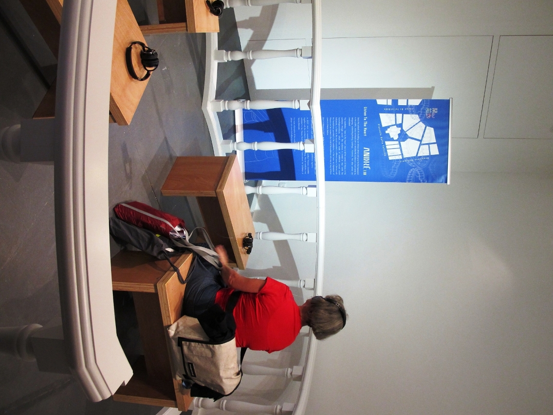 Exhibition-goer in the area ‘Listen to the Heart’ with headphones.