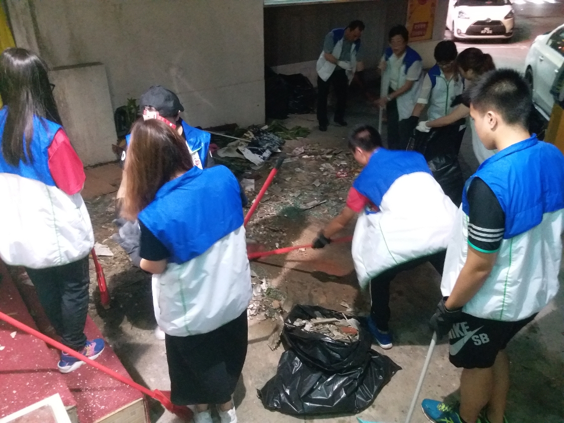 青年義工正努力將颱風後遺下塌樹、玻璃碎片及雜物清理