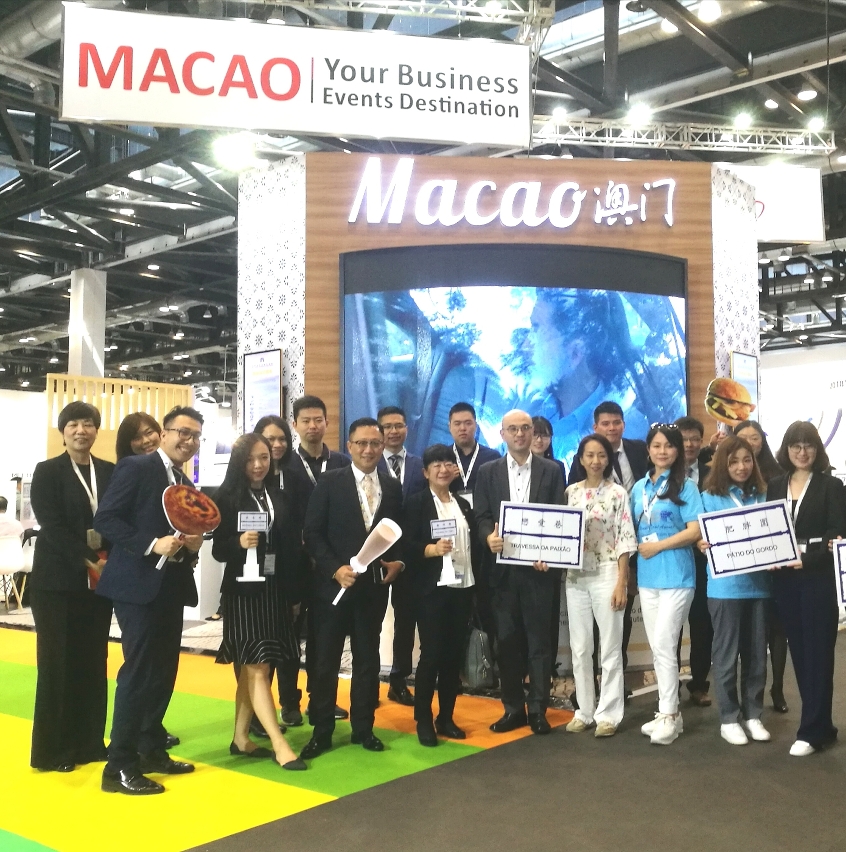 Fotografia de grupo dos representantes do IPIM e dos sectores de convenções e exposições e de turismo de Macau, em frente do “Pavilhão de Macau” instalado no recinto do CIBTM 2017