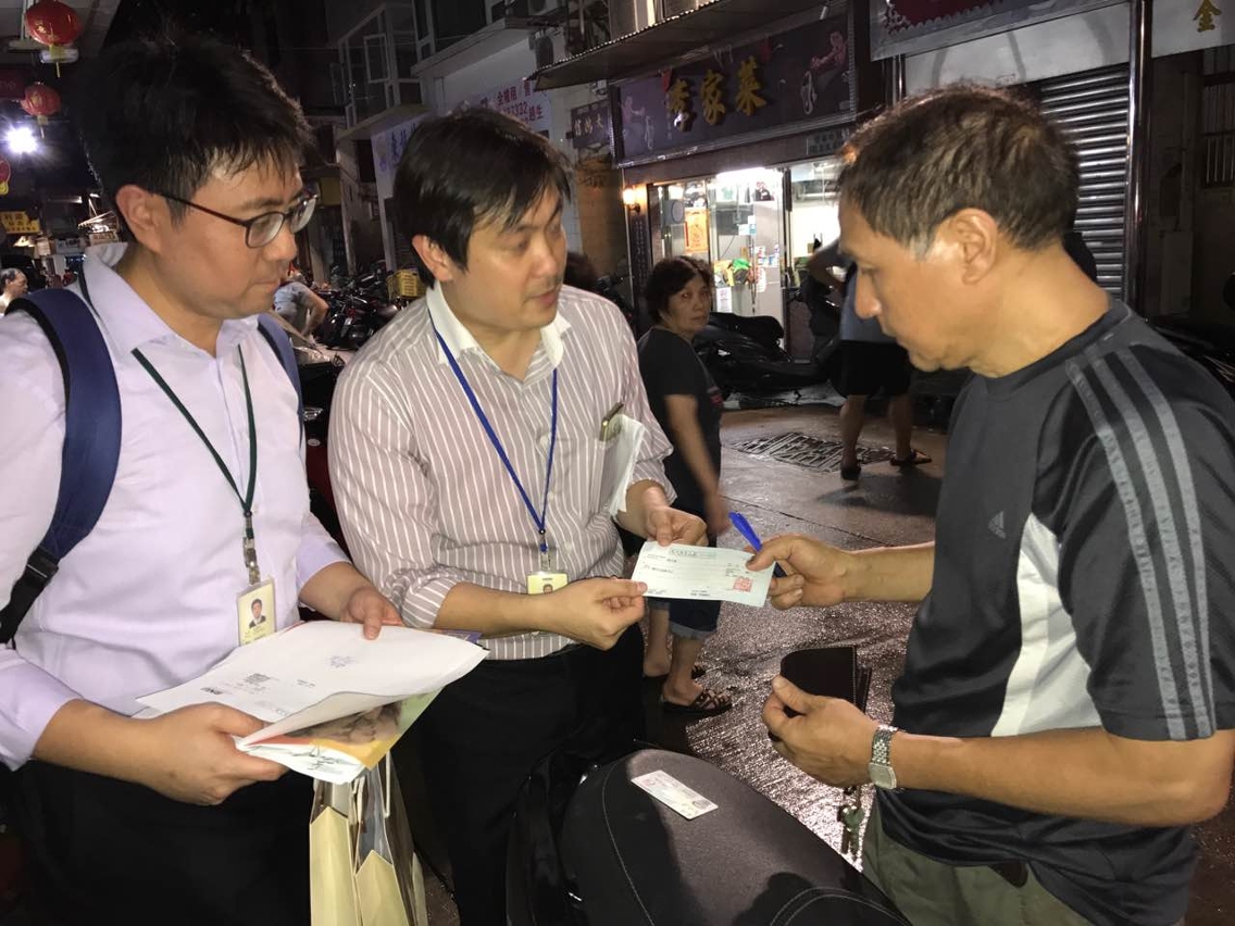 工作人員將首批中小企業災後補助金送到受災中小商戶手中