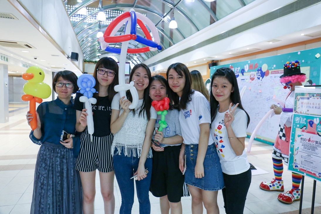 A MPI senior student twists colourful balloons for students