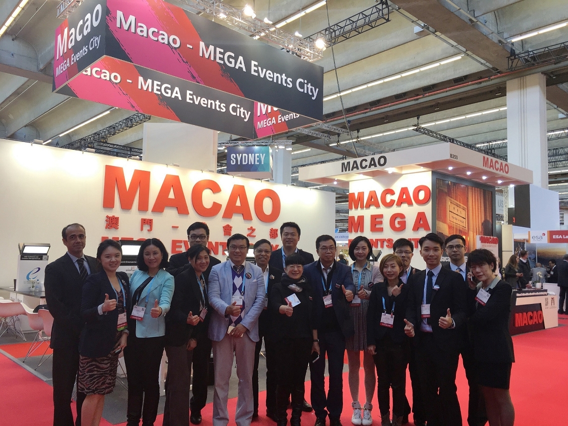 Fotografia de grupo dos Vogal Executiva do IPIM, Dra. Irene Va Kuan Lau e dos sectores de convenções, exposições e turismo, em frente do Pavilhão de Macau instalado no IMEX in Frankfurt