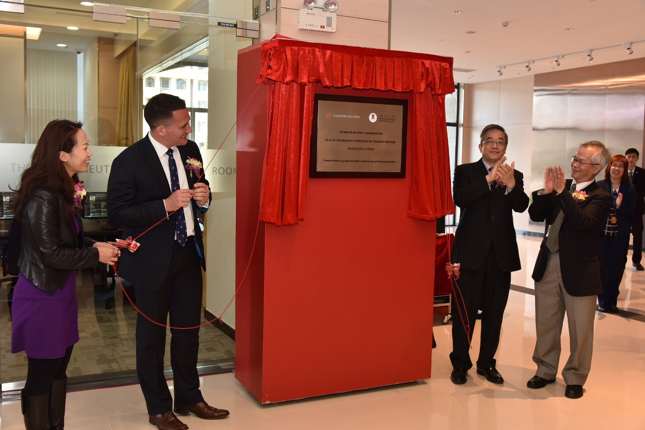 Officiating guests unveil the plaque of the Thomson Reuters Trading Room