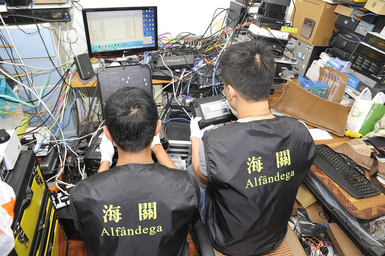 港澳海關首次同步聯手偵破跨境網上侵權案，澳門海關知識產權廳反互聯網侵權偵查小組人員，在涉案單位內作現場取證。