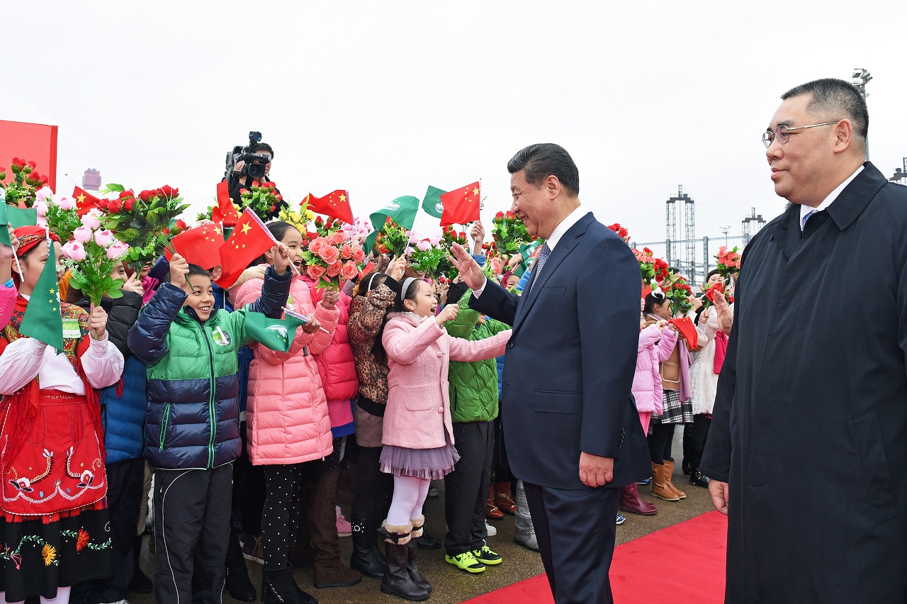 習近平主席受到手持國旗、區旗和絹花的小學生熱烈歡迎