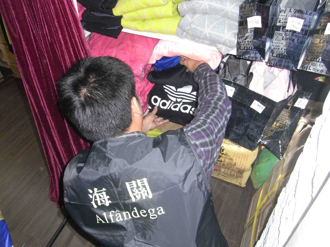 海關偵查人員在該涉案實體店內隱蔽處，搜出涉嫌假冒知名品牌服裝。