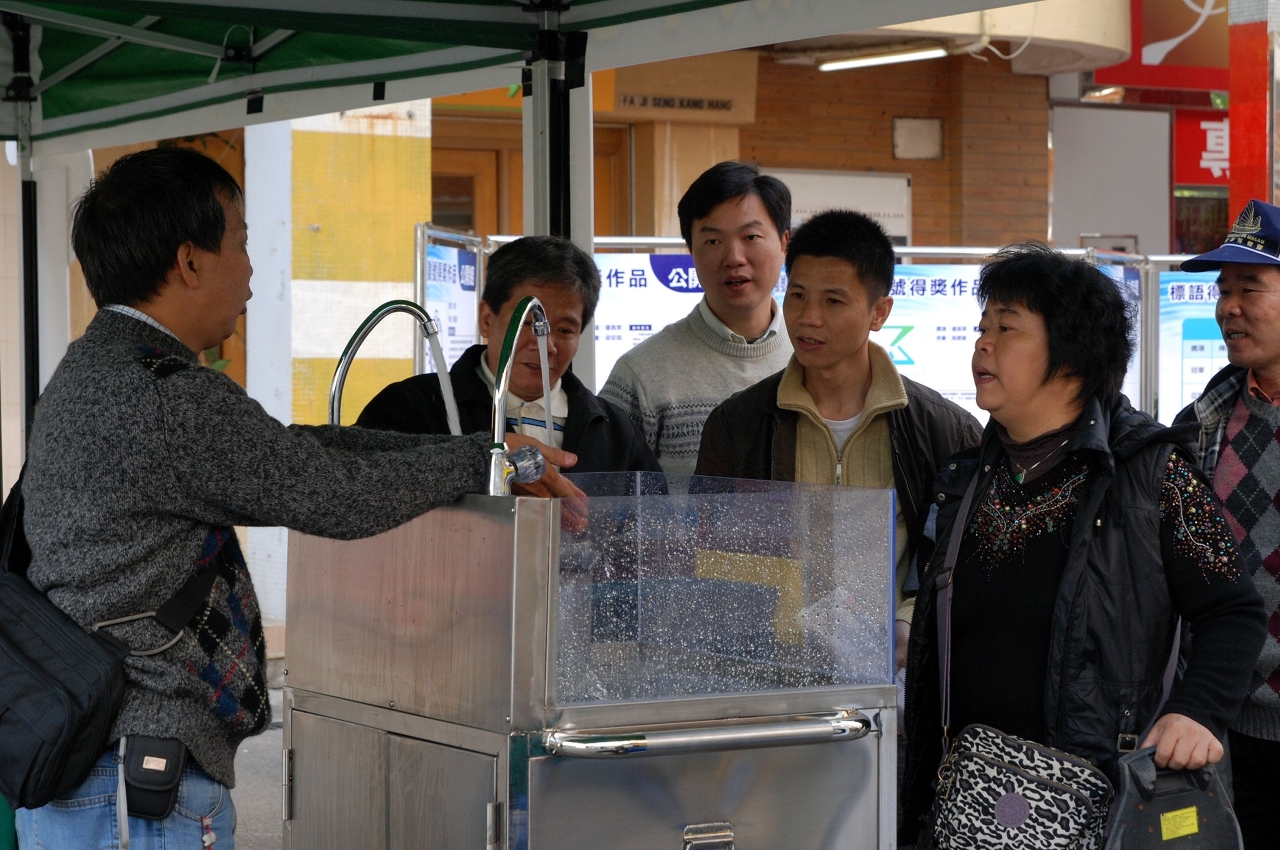 工作人員向市民示範節水器具的安裝方法和節水效能