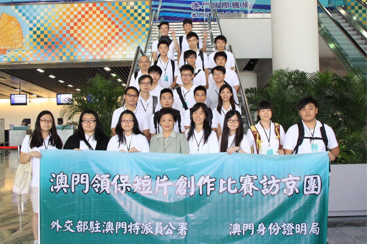Mrs. Zhang Jinfeng, Deputy Commissioner of the Office of the Commissioner of the Ministry of Foreign Affairs of the People’s Republic of China in the Macao SAR, and Mrs. Ao Ieong U, Deputy Director of the Identification Services Bureau of the Macao SAR, are having a group photo with the winners of the short film competition for all Macao secondary school students before departure to Beijing