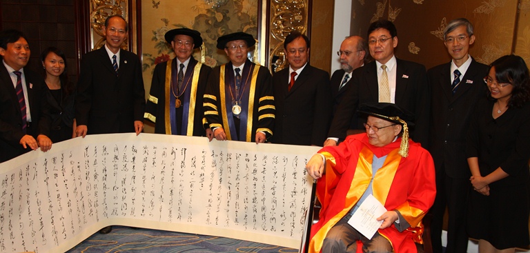 UM presents a Chinese scroll handwritten in cursive style to Dr. Cha.