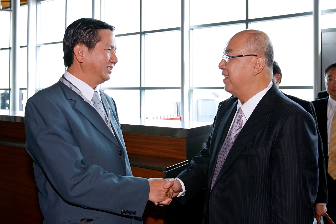 Secretário para os Assuntos Sociais e Cultura, Cheong U (à esquerda), dá as boas-vindas ao presidente honorário do Kuomintang, Wu Po-hsiung (à direita), para participar a 7ª Cimeira Mundial de Empresários Chineses