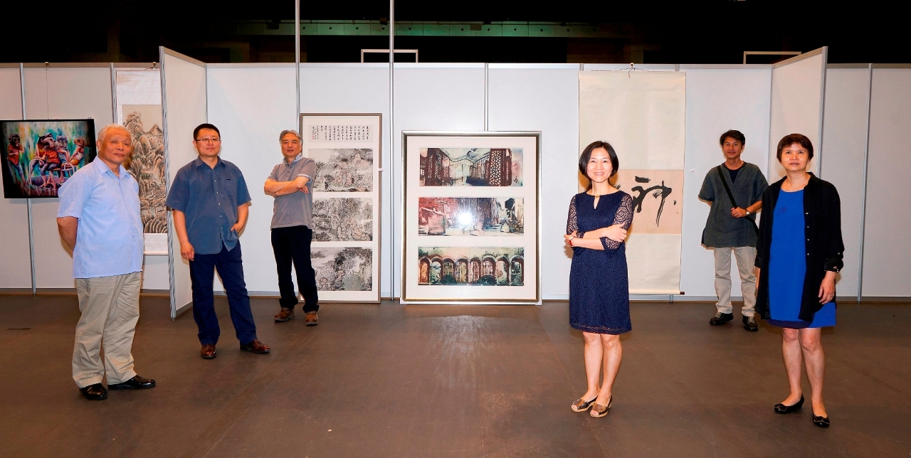 Fotografia do júri em frente das obras premiadas: (a partir da esquerda) o Prof. do Departamento de Belas Artes da Universidade Normal da China Oriental, Liu Qiyi