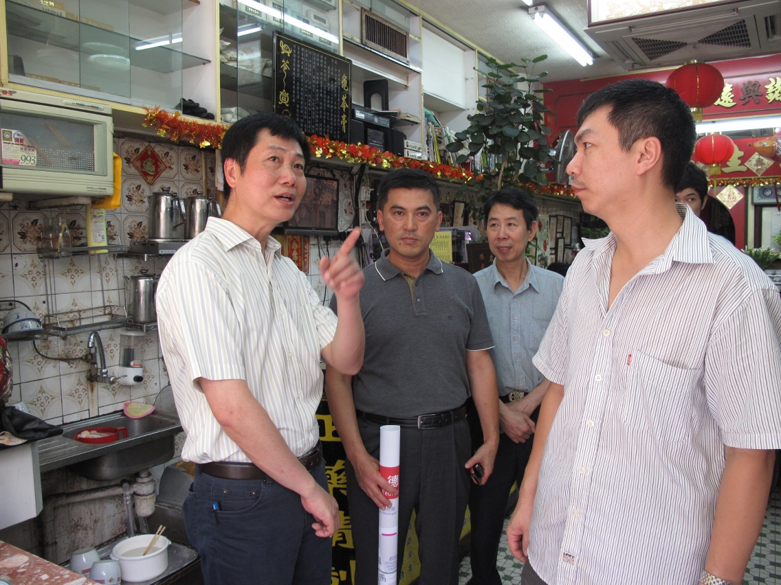 Subdirector da DSSOPT, Shin Chung Low Kam Hong (1.º à esquerda) e o Chefe da Divisão de Coordenação da DSAT, Mok Soi Tou (1.º à esquerda), ouviram as opiniões dos comerciantes.